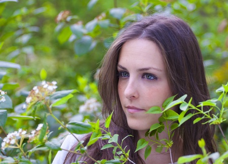 Young attractive woman portraited in the greenery of the city park.の写真素材
