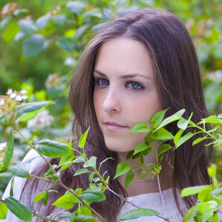 Young attractive woman portraited in the greenery of the city park.の写真素材