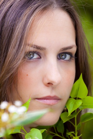 Young attractive woman portraited in the greenery of the city park.の写真素材