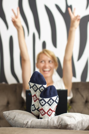 Exited beautiful young lady using web on the laptopの写真素材