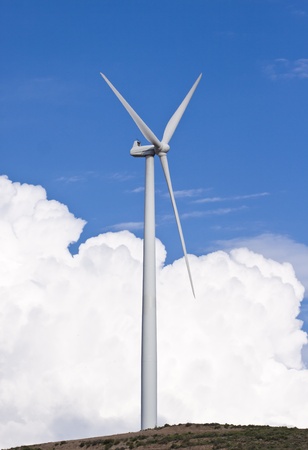 Wind turbine generating electricity with a nice white cloud on the skyの写真素材