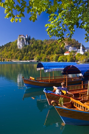 Traditional wooden boats on lake Bled, with the rocktop castle in the background  Sloveniaのeditorial素材