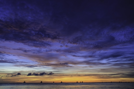 Sailboats in dramatic colorful sunset.の写真素材