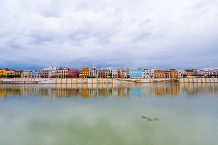 Colorful panorama of Seville riverside on the overcast day, forming amazing pastel colors and reflections in the river.の写真素材