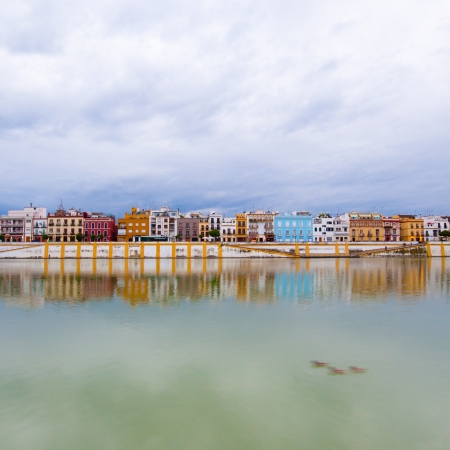 Colorful panorama of Seville riverside on the overcast day, forming amazing pastel colors and reflections in the river.の写真素材