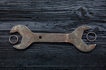 Wedding rings and a screwdriver on a dark wooden background.の写真素材