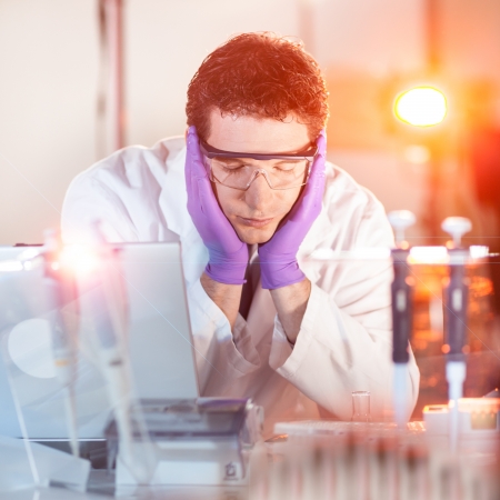 Burned up young post doc PhD researcher sleeping in the laboratory while doing overtime experiments late at night.の写真素材