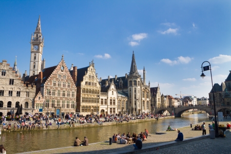 GHENT, BELGIUM - 21 APRIL : Picturesque medieval buildings overlooking the "Graslei harbor" on Leie river in Ghent, Belgium on 21 April 2013. People gathered on the banks of the river Leie enjoy a sunny Sunday afternoon.のeditorial素材