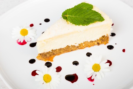 Dessert - Cheesecake with Green Mint decorated with dasiy flowers and decorated with fruit syrup drops の写真素材