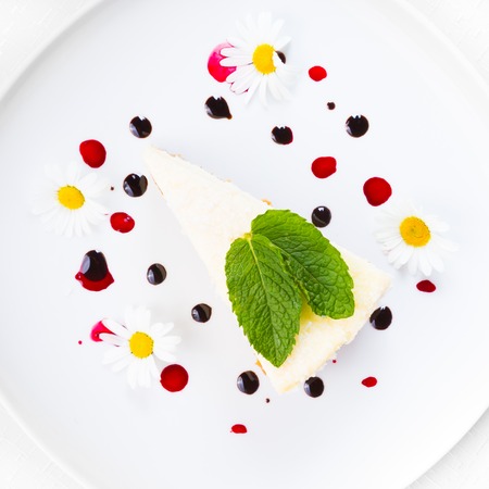 Dessert - Cheesecake with Green Mint decorated with dasiy flowers and decorated with fruit syrup drops の写真素材