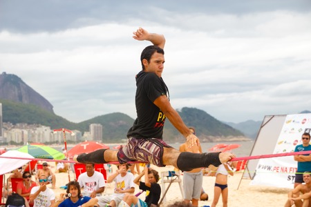 RIO DE JANEIRO - NOVEMBER 03 2012  Slackline contestant on the sands of Copacabana in Rio Elephant Cup tournament, held on November  03, 2012 on Copacabana, Rio de Janeiro, Brazil のeditorial素材