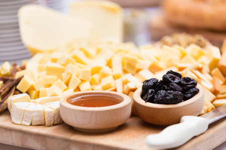 Cheese Plate with Dried Fruit and Honey. Rustic decoration on a wooden plate.の写真素材