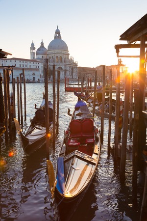 Venice, Italy - October 31, 2014: Traditional wooden boads and a gondolier in the Grand Canal in front of Santa Maria della Salute in sunset.のeditorial素材