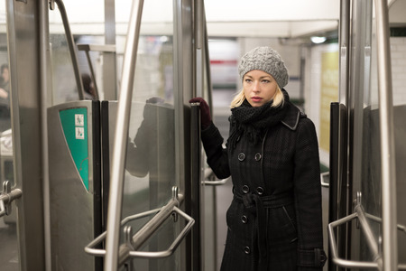 Beautiful blonde caucasian lady entering the metro station. Public transport.の写真素材