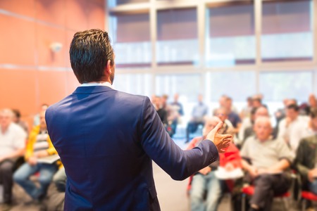 Speaker at Business Conference with Public Presentations. Audience at the conference hall. Entrepreneurship club. Rear view. Horisontal composition. Background blur.の写真素材