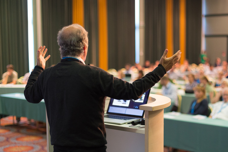 Speaker at Business Conference with Public Presentations. Audience at the conference hall. Business and Entrepreneurship concept. Rear view. Horisonatal composition. Background blur.の写真素材