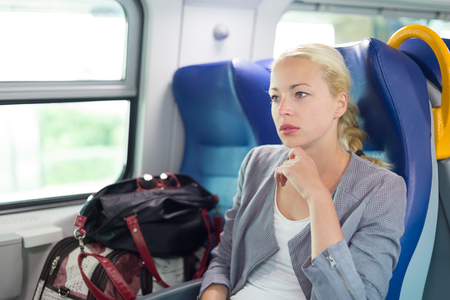 Blonde caucasian business woman traveling by train. Business travel concept.の写真素材