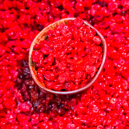 Scoop of dried cranberries beeing sold on local food market.の写真素材