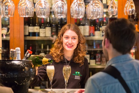 Madrid, Spain - Jan 25, 2016:  Waitress serving champagne at Mercado San Miguel on January 25th, 2016 in Madrid, Spain. It is one of top people socializing destinations in Madrid.のeditorial素材