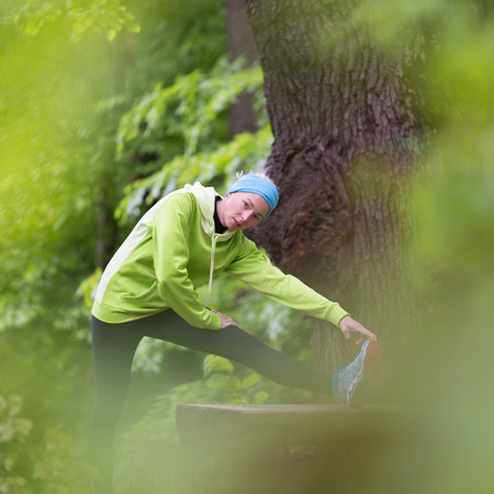 Sporty young female working out in forest.  Female runner during outdoor workout in nature. Fitness model outdoors. Weight Loss. Healthy lifestyle.の写真素材