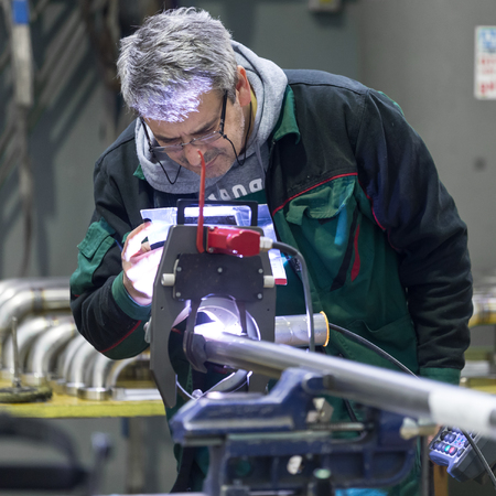 Industrial operator setting  computer controlled process of orbital welding machine in  stainless...