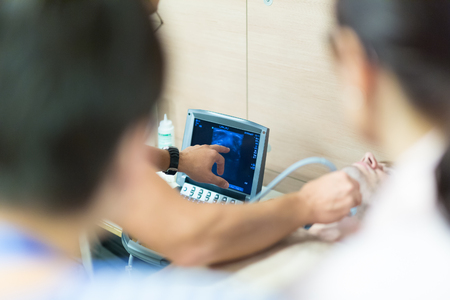 Medical doctor students learning to do medical examination of patient with ultra sound scanner machine on ultrasound techniques workshop.の写真素材