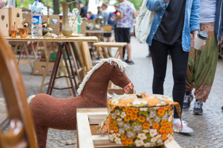 Market boot with objects beeing selled at the weekend flea market in Berlin city center. Out of focus curious visitors in the background.の写真素材