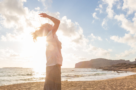 Relaxed woman enjoying sun, freedom and life an a beautiful sandy beach. Young lady feeling free,...