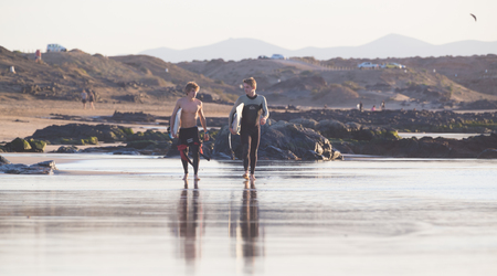 EL Cotillo, Spain - Dec 22, 2015:  Two surfers walking down El Cotillo beach, famous surfing destination on Fuerteventura, Canary Islands, Spain on December 22, 2015.のeditorial素材