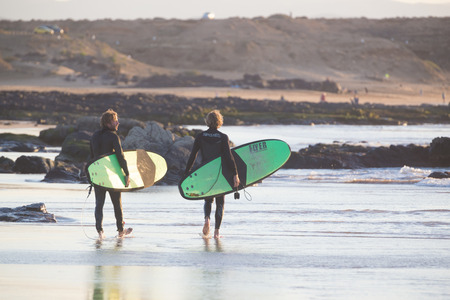 EL Cotillo, Spain - Dec 22, 2015:  Two surfers walking down El Cotillo beach, famous surfing destination on Fuerteventura, Canary Islands, Spain on December 22, 2015.のeditorial素材