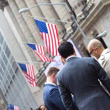 New York City, United States of America - March 26: Businessmen talking on Wall street in front of New York Stock Exchange on March 26, 2015.のeditorial素材