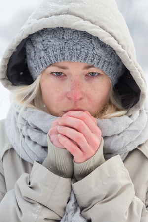 Portrait of cute casual young woman outdoor in snow in cold winter time.の写真素材