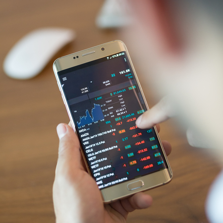 Close up of a businessman using smart phone. Focus on mobile device.の写真素材