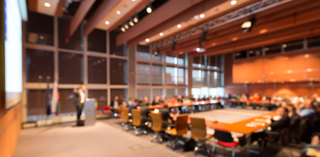 Speaker giving a talk on corporate business event. Audience at the conference hall. Business and Entrepreneurship event. Out of focus image. Unrecognizable business people.の写真素材