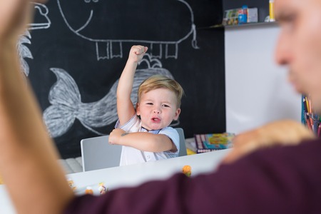 Cute little playfull toddler boy at child therapy session. Private one on one homeschooling with didactic aids.の写真素材