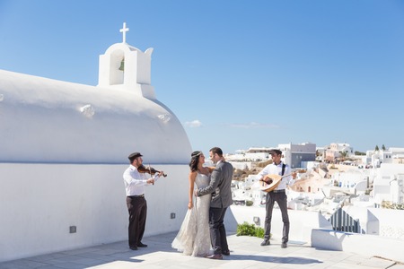 Oia, Santorini island, Greece - Oct 11, 2017: Bride and groom dancing during wedding ceremony with traditional musicians and singers on Santorini island on 11th of October, 2017 on Santorini, Greece.のeditorial素材