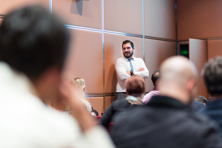 Relaxed Businessman Giving a Talk at Informal Business Meeting. Audience in the conference hall. Business and Entrepreneurship concept.の写真素材