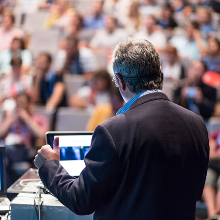 Speaker giving a talk on corporate business conference. Unrecognizable people in audience at conference hall. Business and Entrepreneurship event.の写真素材