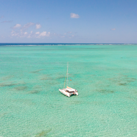 Aerial view of Catamaran boat sailing in turquoise lagoon of Ile aux Cerfs Island lagoon, Mauritius.の写真素材