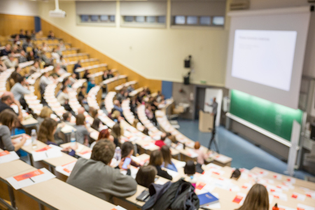 Defocused image of audience at the conference hall. Conference and Presentation. Business and Entrepreneurship. Faculty lecture and workshop. Audience in the lecture hall. Participants making notes.の写真素材