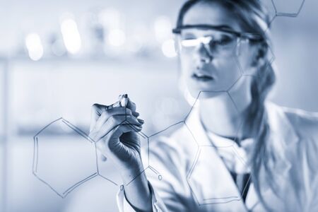 Portrait of a confident female health care expert in life science laboratory writing structural...