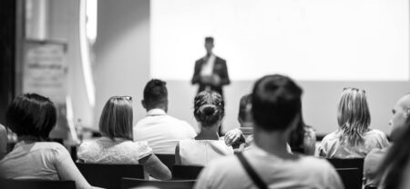 Speaker giving talk at business event. Audience at the conference hall. Business and Entrepreneurship concept. Focus on unrecognizable people in audience. Black and white photo.の写真素材