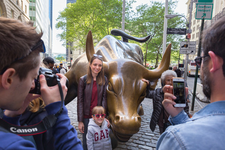 New York City, USA - May 18, 2018: Tourists taking photos of Charging Bull, landmark in Lower Manhattan representing the strength and power of the American People, on 18th of May, 2018 in NY, USA.のeditorial素材