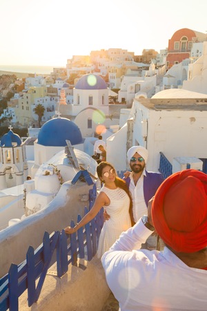 Oia, Santorini, Greece - Oct 10, 2017: Indian tourists wearing colorful traditional sikhs clothes and turbans taking travel photos on Santorini island on 11th of October, 2017 on Santorini, Greece.のeditorial素材