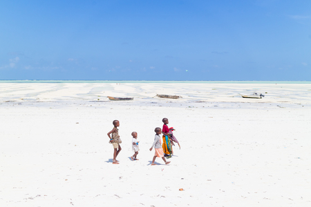 Paje, Zanzibar - Feb 9, 2015: Local kids walking at Paje village picture perfect white beach at low tide on February 9th, 2015 on Zanzibar, Tanzania.のeditorial素材