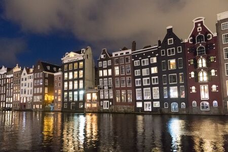 Amstedam, capital of Netherlands. Beautiful tranquil scene of city of Amsterdam at dusk. Bicycles along the street and on the bridge over the canal.の写真素材