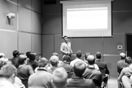 Speaker giving a talk at conference meeting business event. Audience at the conference hall. Business and Entrepreneurship concept. Black and white image.の写真素材