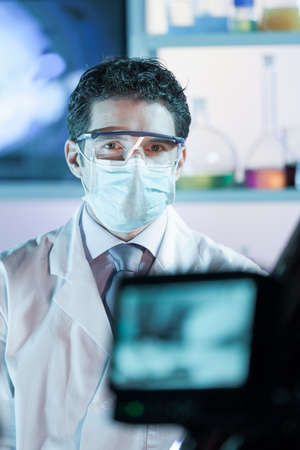 Laboratory hospital clinic doctor, scientist or exper, wearing protacive mask while addressing...