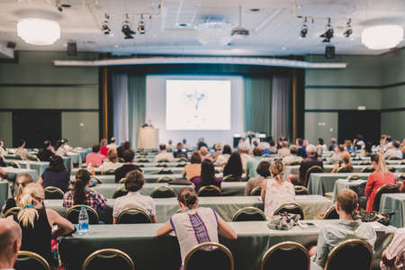 Speakers Giving a Talk at Business Meeting. Audience in the conference hall. Rear view. Business and...