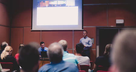 Business speaker giving talk at business conference event.